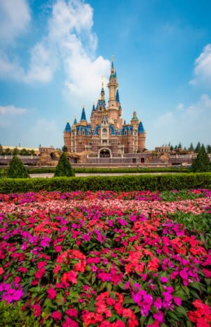 enchanted-storybook-castle-daytime-puffy-clouds-flowers-shanghai-disneyland